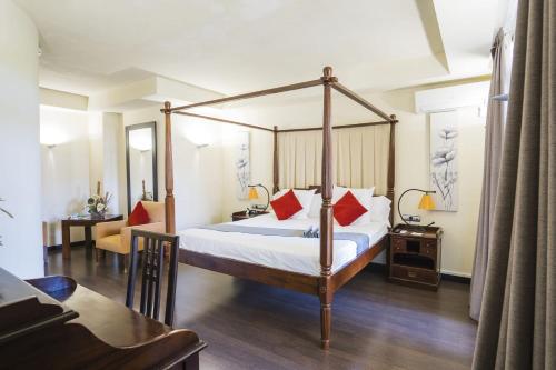 a bedroom with a canopy bed with a desk and a chair at Hotel Alda Castillo de Olite in Olite