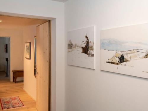 a hallway with three paintings on a wall at Apartment Grace by Interhome in Gstaad