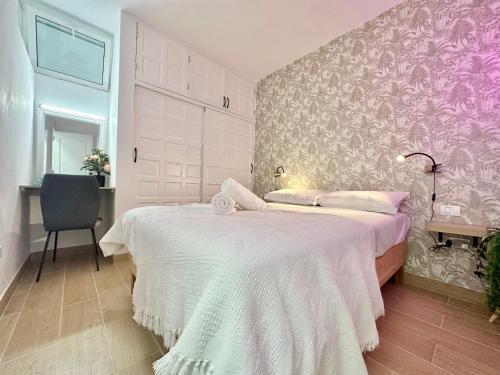1 dormitorio con 1 cama blanca grande y pared morada en Retiro del Acantilado, en San Marcos