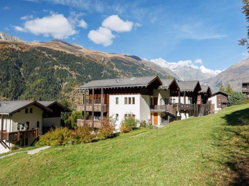 a resort on a hill with mountains in the background at Apartment Aragon M88 by Interhome in Ernen