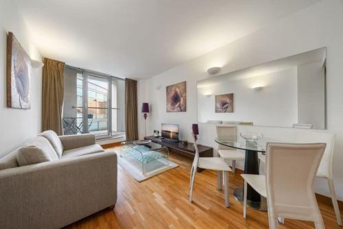 a living room with a couch and a table at Stylish and very central apartment with balcony in London