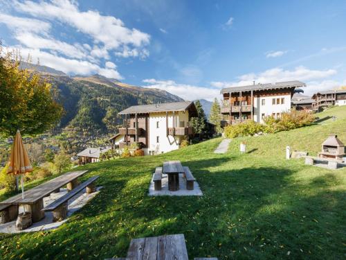a park with benches and buildings on a hill at Apartment Aragon M88 by Interhome in Ernen