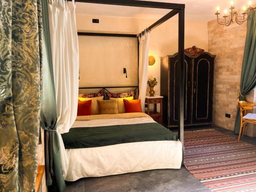 a bedroom with a canopy bed with orange pillows at La Mia Amore in Kotor