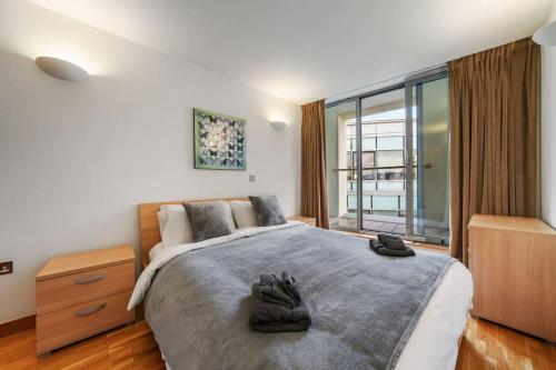 a bedroom with a large bed with shoes on it at Stylish and very central apartment with balcony in London