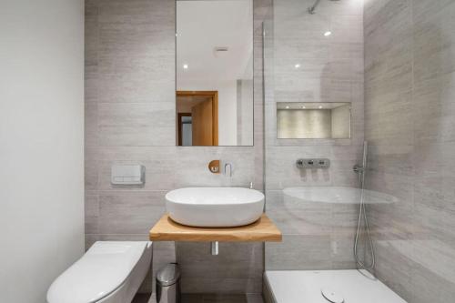 a bathroom with a sink and a mirror and a tub at Stylish and very central apartment with balcony in London