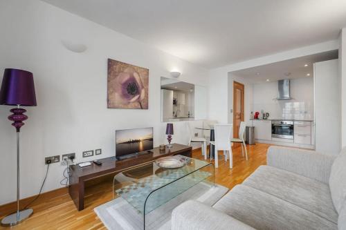 a living room with a couch and a table at Stylish and very central apartment with balcony in London