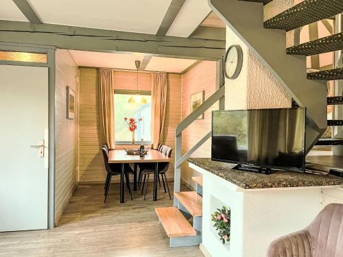 ein kleines Esszimmer mit einem Tisch und einem TV in der Unterkunft Holiday Home Dorf 3-Haus 112 by Interhome in Kirchheim
