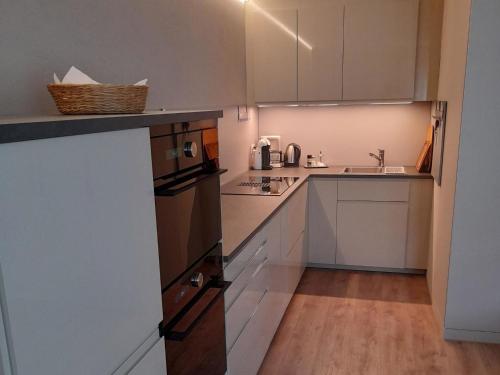 a small kitchen with white cabinets and a sink at Apartment Erlenrain Wohnung 911 by Interhome in Engelberg
