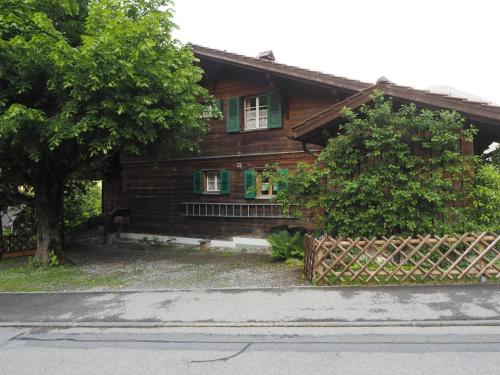a wooden house with a fence in front of it at Apartment Hübeli - Kopp by Interhome in Zweisimmen