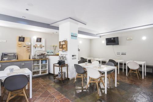Un comedor con mesas y sillas y una cocina. en Hotel Alda Castillo de Olite, en Olite