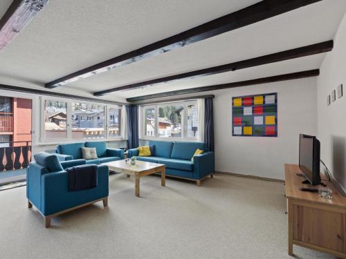a living room with blue couches and a tv at Apartment Seeli by Interhome in Churwalden