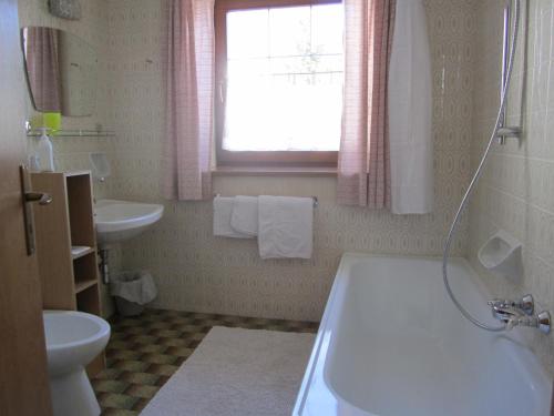 a bathroom with a sink and a tub and a toilet at Pension Schönblick in Campo di Trens