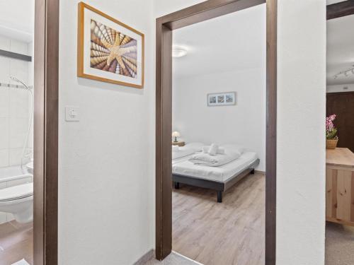 a door leading to a bathroom with a bed at Apartment Seeli by Interhome in Churwalden