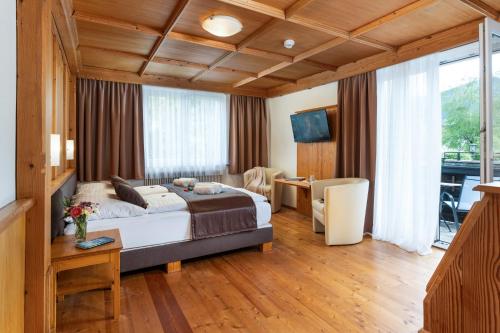 a bedroom with a bed and a table and a desk at Landhaus St. Georg in Gröbming