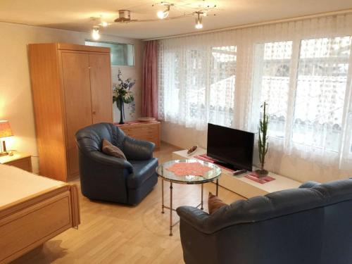 a living room with two leather chairs and a television at Apartment Studio Poli by Interhome in Zweisimmen