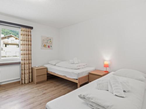 a bedroom with two beds and a window at Apartment Seeli by Interhome in Churwalden
