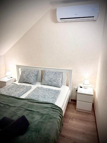 a bedroom with a bed and a air conditioner on the wall at AIRPORTMAX Panzió in Vecsés