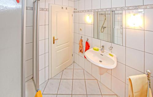 a white bathroom with a sink and a mirror at Ferienwohnung Wesenberg in Strasen