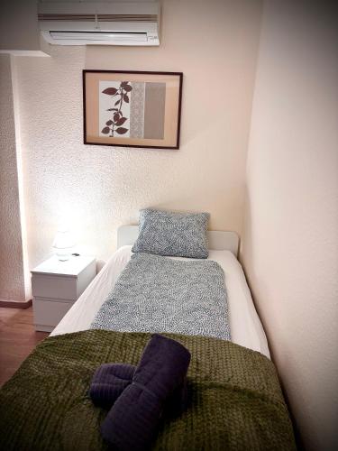 a small bedroom with a bed and a blanket at AIRPORTMAX Panzió in Vecsés