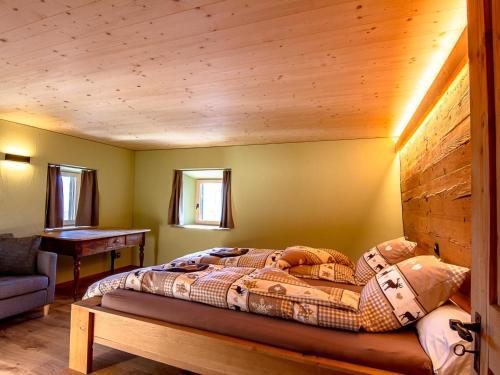 a bedroom with a bed with a wooden wall at Apartment Ferienhaus Tgioc by Interhome in Obervaz