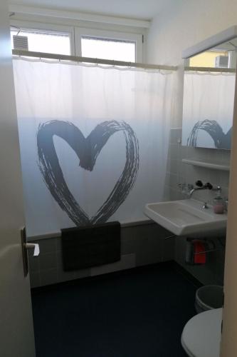 a bathroom with a heart drawn on the shower curtain at Apartment Tgiesa Canols by Interhome in Valbella