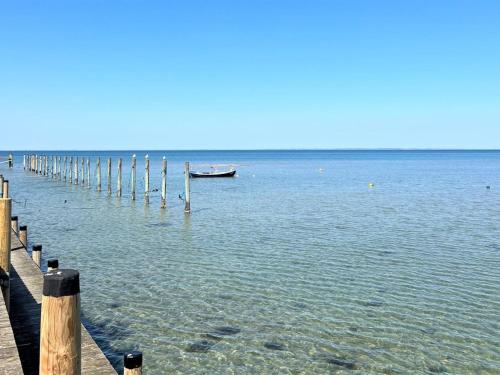 a boat in the water next to a pier at Holiday Home Aurore - 1-3km from the sea by Interhome in Fårevejle