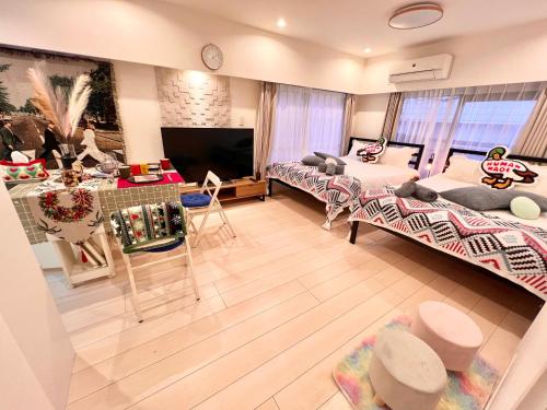 a living room with two beds and a tv at High-end Tokyo shinjuku Central Park Flat 2 in Tokyo