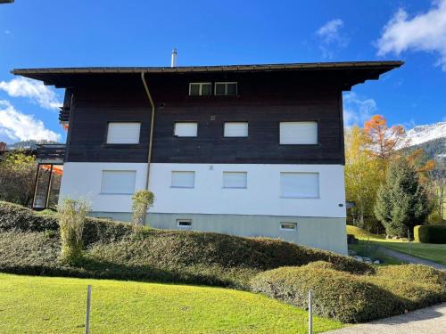 a building with a black and white at Apartment Ferienwohnung Waldrand EG by Interhome in Lenk