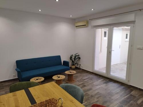a living room with a blue couch and a table at chez sandrou in Aigues-Mortes