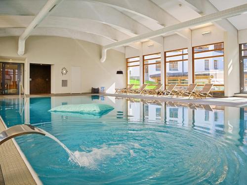 a large swimming pool with chairs in a building at Apartment Schweizerhof 502 by Interhome in Lenzerheide