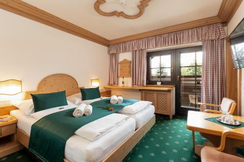 a hotel room with a large bed with towels on it at Landhaus St. Georg in Gröbming