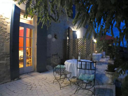 - une table et des chaises devant un bâtiment la nuit dans l'établissement gite de charme au milieu des vignes, à Massugas
