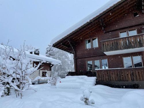una casa cubierta de nieve delante de ella en Apartment Chalet Ilge by Interhome, en Lenk