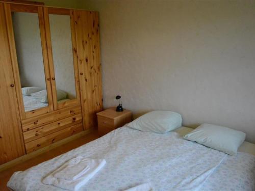 a small bedroom with a bed and a mirror at Apartment Henry - 1- Stock by Interhome in Schönried