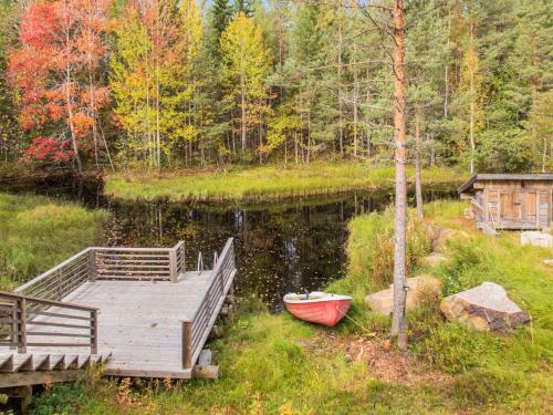 a dock with a boat next to a lake at Holiday Home Purontupa by Interhome in Sotkamo
