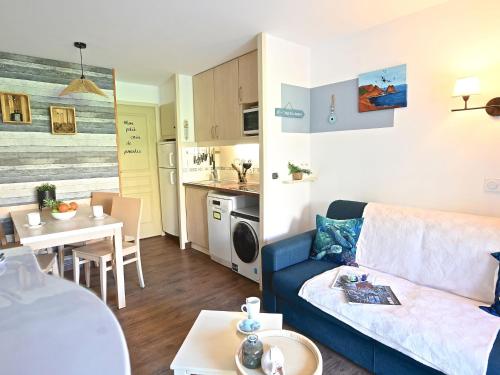 un salon avec un canapé bleu et une cuisine dans l'établissement Apartment L'Esquinade J3 029 by Interhome, à Saint-Raphaël