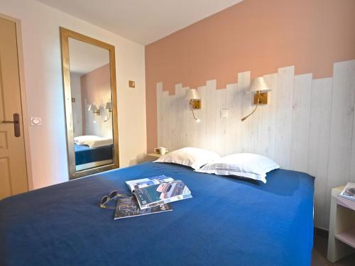 - une chambre avec un lit bleu et un miroir dans l'établissement Apartment L'Esquinade J3 029 by Interhome, à Saint-Raphaël