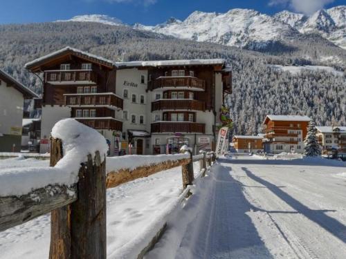 a snow covered street in front of a building at Apartment Haus Evita by Interhome in Saas-Grund