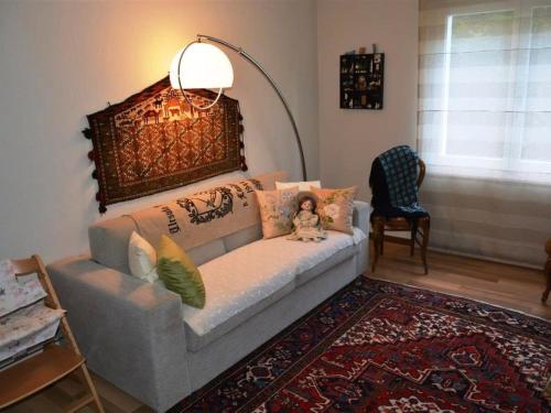 a living room with a couch with a doll sitting on it at Apartment Hübeli - Arm by Interhome in Zweisimmen