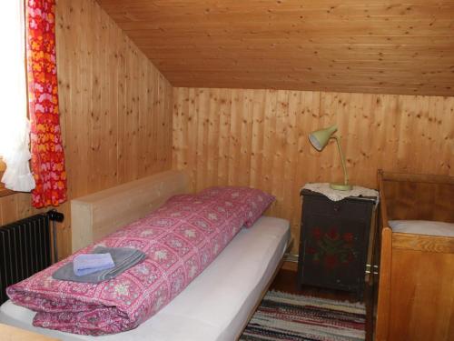 a bedroom with a bed in a wooden room at Apartment Beatrice by Interhome in Schönried