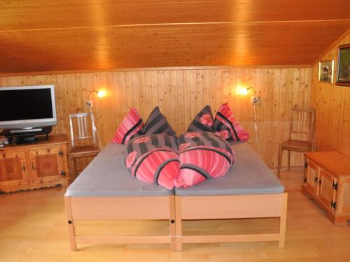 a room with a bed with pillows and a tv at Apartment Trachsel-Huus by Interhome in Lenk