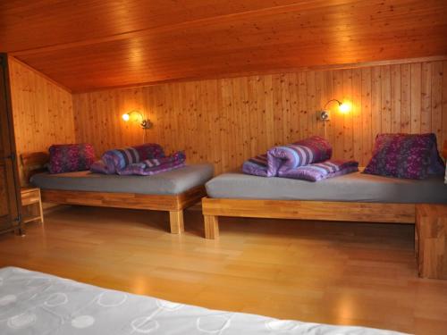 two benches in a wooden room with pillows on them at Apartment Trachsel-Huus by Interhome in Lenk