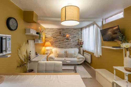 - un salon avec un canapé blanc et un mur en briques dans l'établissement Hidden Chic, à Orléans