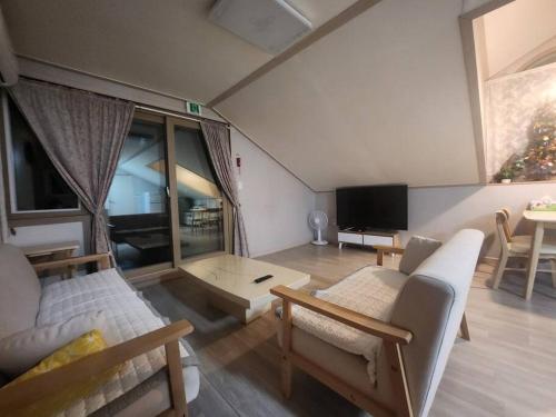a living room with a couch and a tv at Gozneok spacious private house - 75py in Goseong