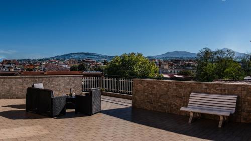 a patio with two chairs and a bench on a roof at a casa di Ma Gi in Ciampino