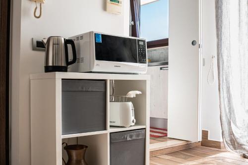a microwave on top of a white shelf in a kitchen at a casa di Ma Gi in Ciampino