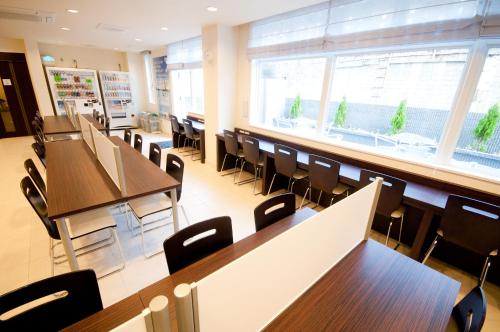 a restaurant with tables and chairs and a large window at Super Hotel Kokuraeki Minamiguchi in Kitakyushu