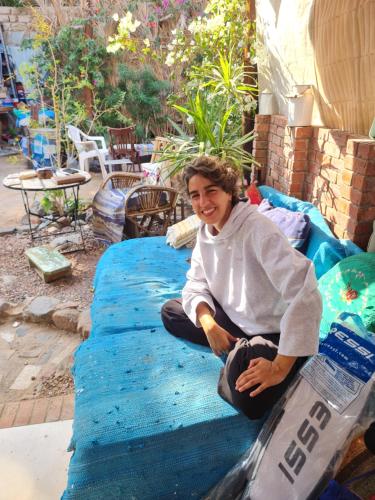 a man sitting on a mattress on a patio at Andyvone at yvone in Dahab