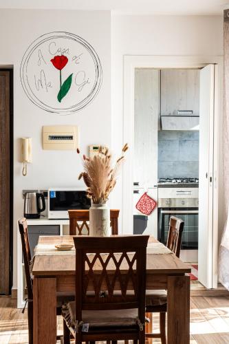 a kitchen with a wooden table with chairs and a clock on the wall at a casa di Ma Gi in Ciampino