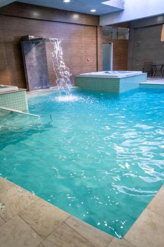 a large swimming pool with a water fountain at Pousada Pedra da Ilha in Penha